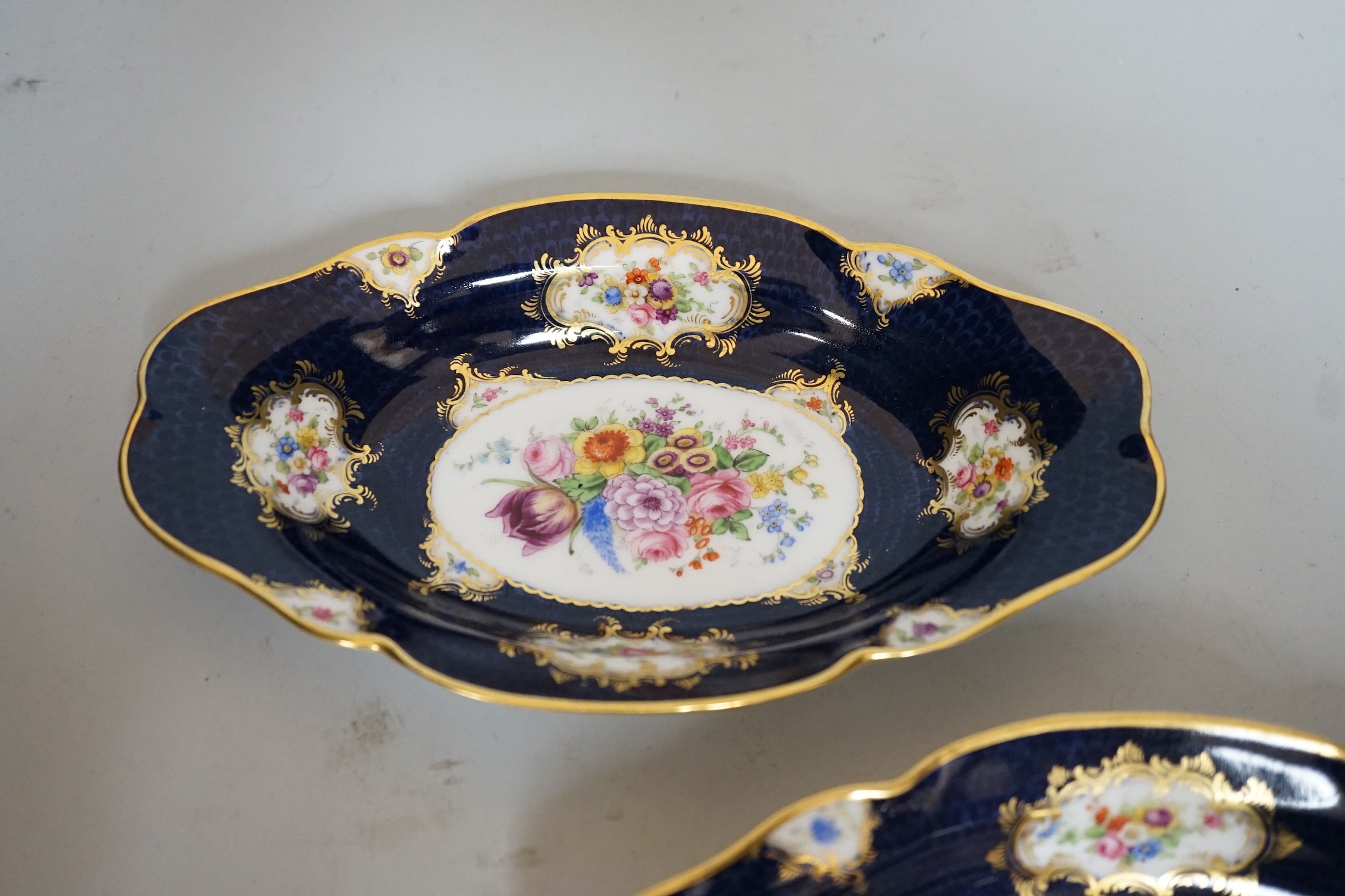 A pair of Royal Worcester blue ground floral painted dishes by E Phillips, signed date code for 1894, length 21cm